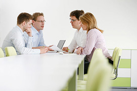 Businessfotografie einer Kommunikationssituation am Tisch. Mitarbeiter bei der Besprechung. Positives Unternehmensbild für ein Bonner Unternehmen.